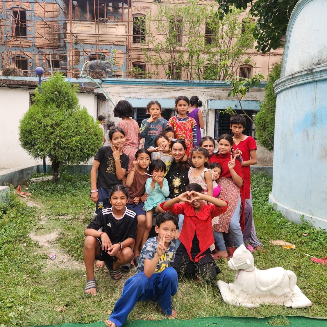 Pooja surrounded by children in the garden at Bal Mandir