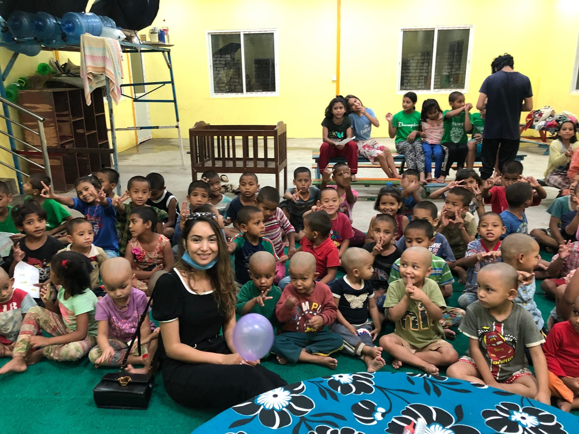 Pooja sitting on the floor of the hall surrounded by children