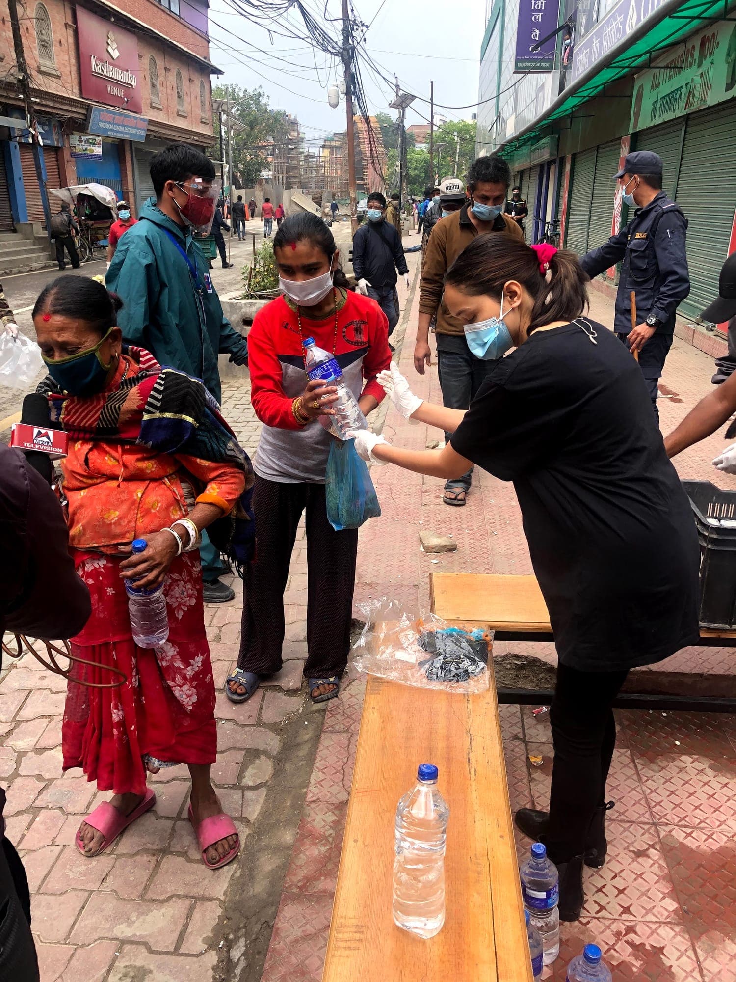 A woman receiving a bottle of water at the street distribution table