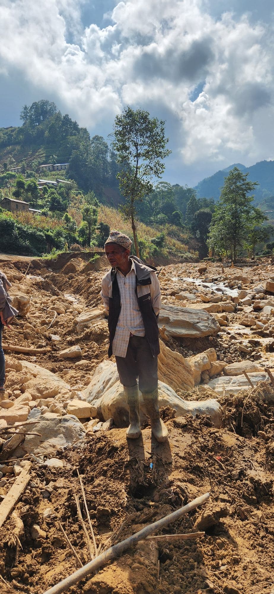 A man standing in the debris where the river came through
