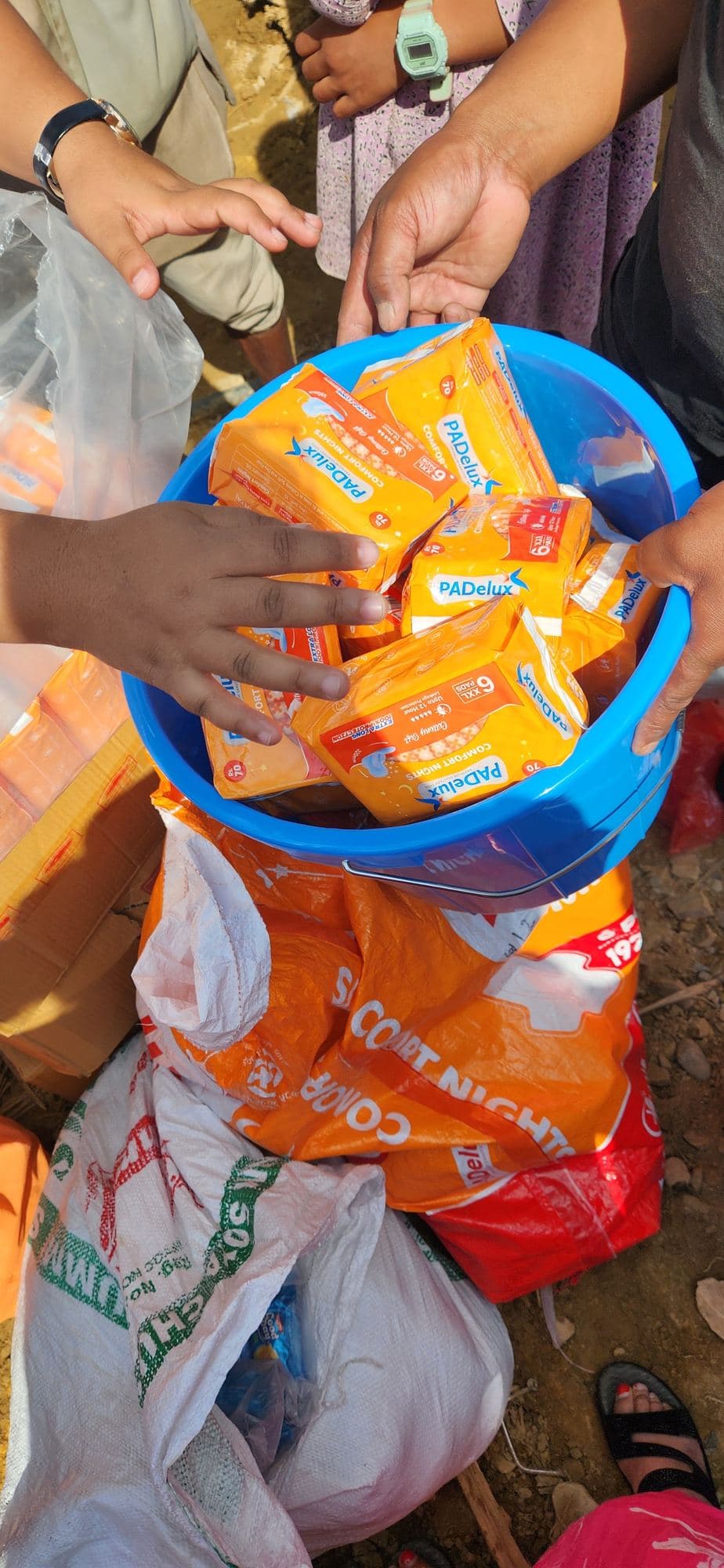Hands holding a bowl of relief supplies being packed