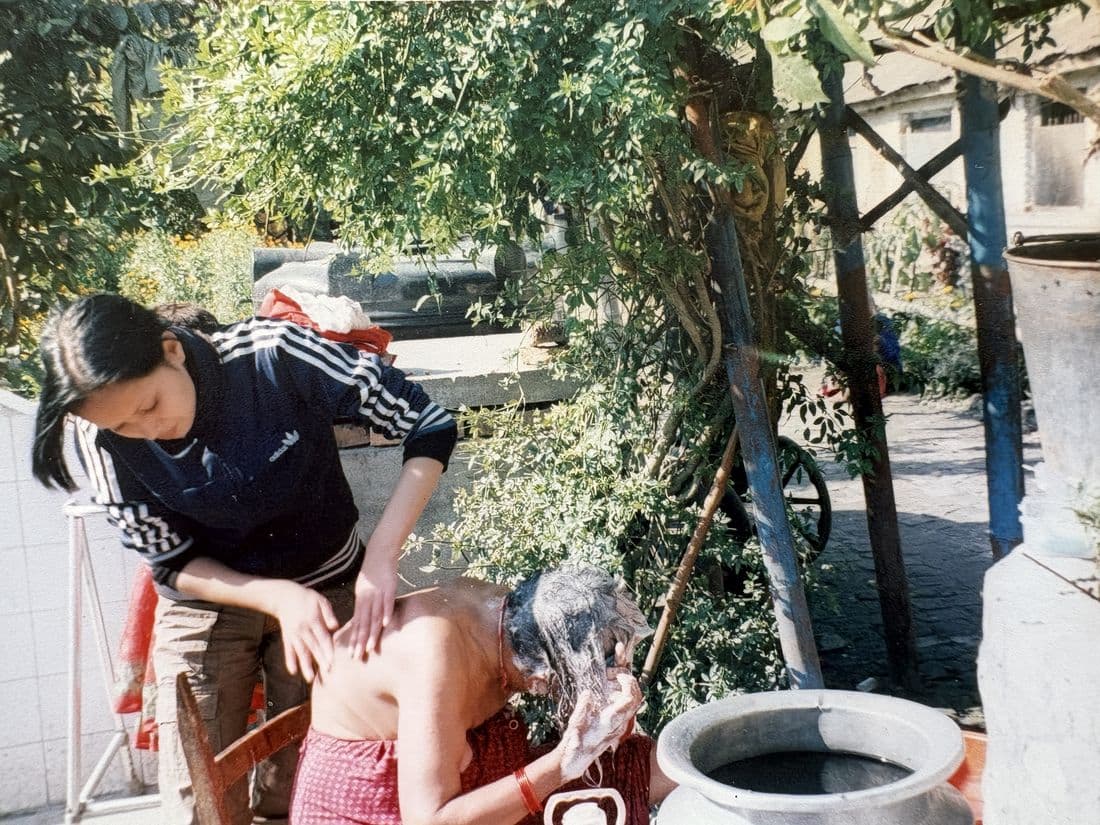 Pooja, as a young volunteer at an old age home, helping an elderly woman wash