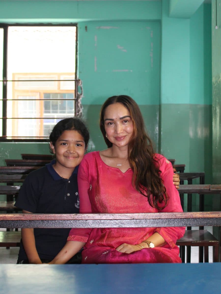 Pooja Pyakurel today, sitting beside a schoolgirl in a classroom