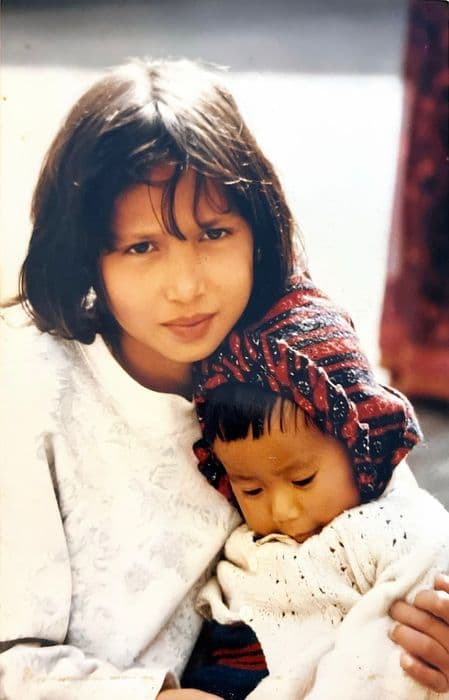 Pooja holding a small child wrapped in a shawl