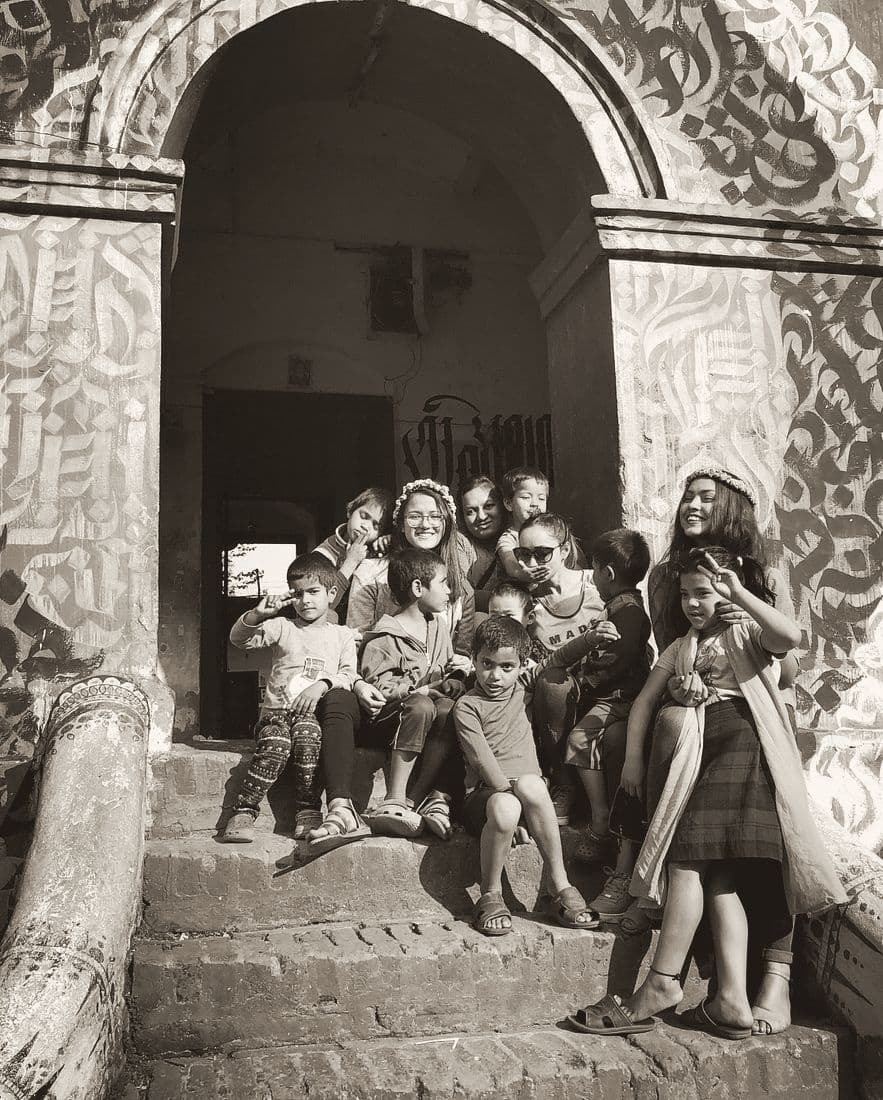 Pooja and children sitting together on temple steps