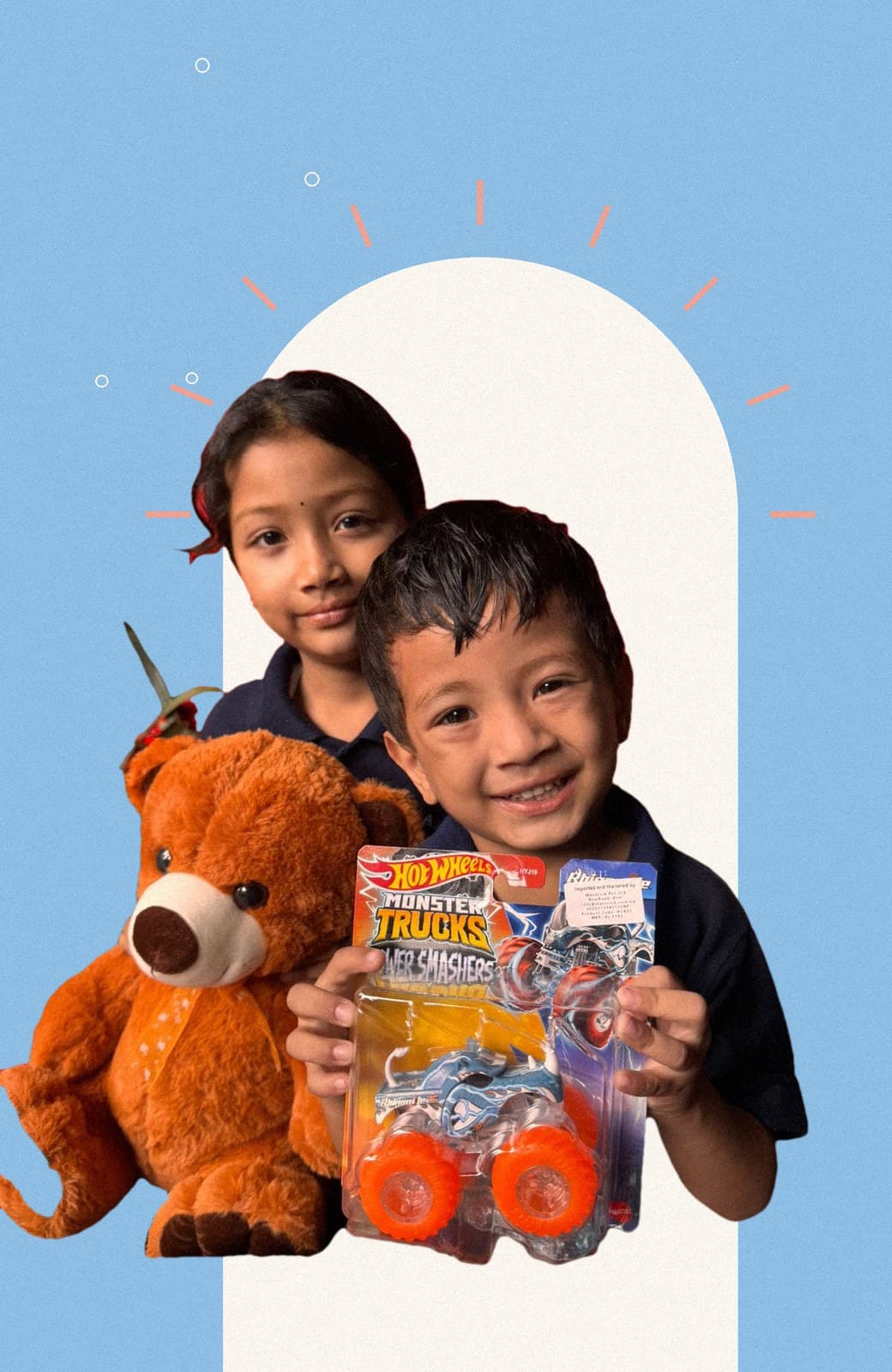 Advik holding up a toy truck, Aditi behind him with a teddy bear