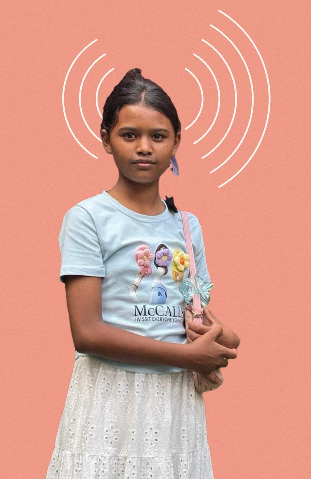 Roshmi standing in a garden, holding her bag