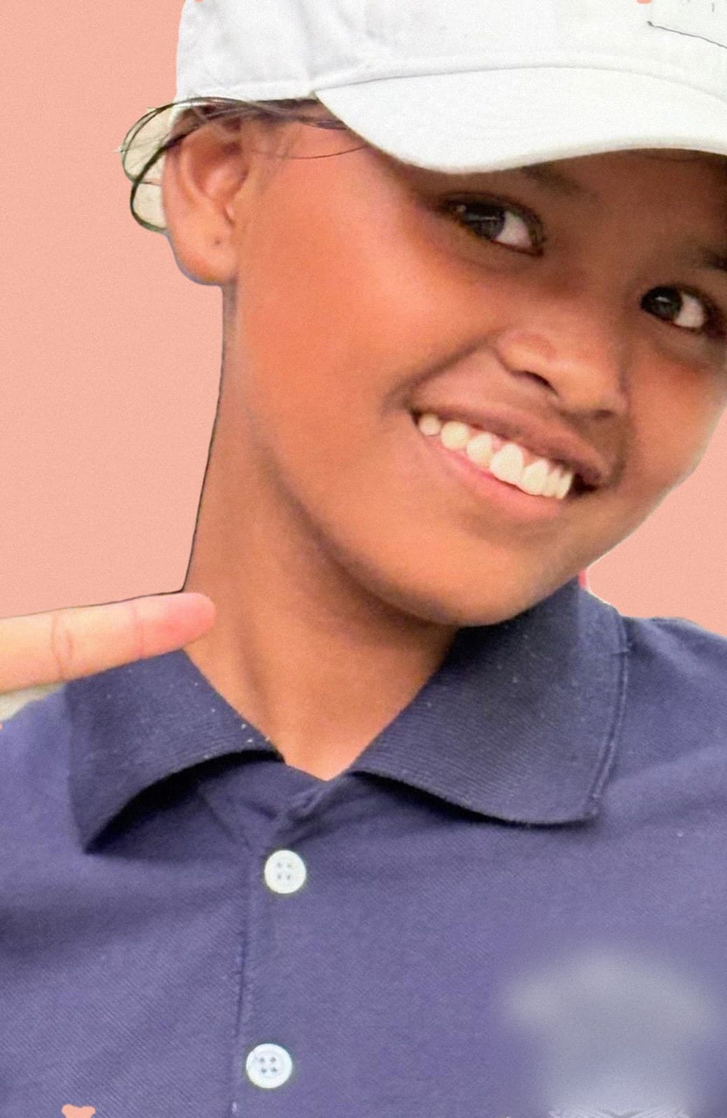 Roshmi smiling in a white cap